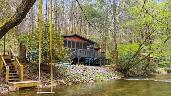 Experience the serene melodies of the nearby creek as children playfully swing above its gentle currents.