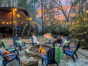 Listen to the soothing sound of the creek while basking in the warm glow of the bonfire as the sun sets in a breathtaking display