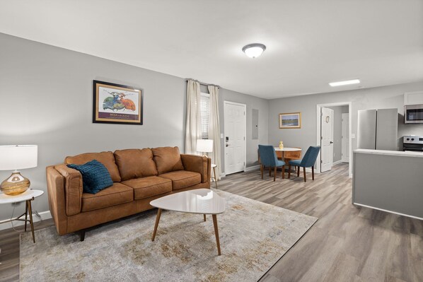 Open-concept space with cozy sofa, accent pillows and sleek table.