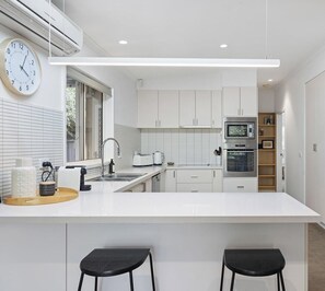 Well-appointed spacious kitchen with breakfast bar for two