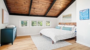 Master bedroom with beautiful vaulted ceilings and cozy king sized bed. This room has a stunning master bathroom attached with a sunlight and large shower.