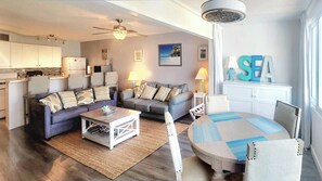 Living room with a full-size sleeper sofa, and a queen Murphy bed in the sunroom