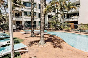 Relax by the shared heated pool, surrounded by lush palms – the perfect spot to soak up the sun.