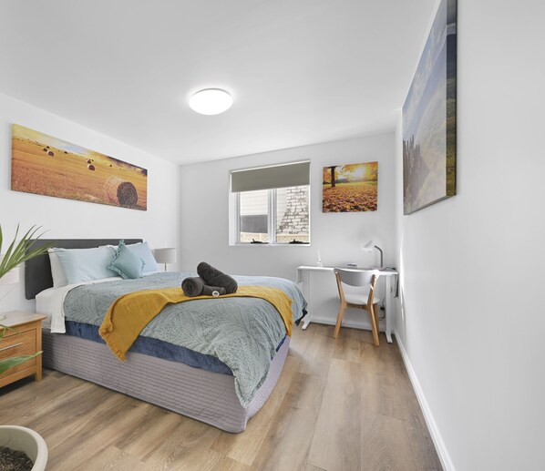 Bedroom with built in wardrobe and workspace area.