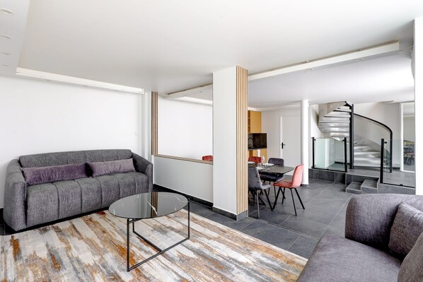Bienvenue dans notre sublime séjour accompagné de ses 2 grands fauteuils, une grande cuisine avec une table à manger pour toute votre famille