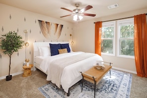 Bedroom with plush king bed and windows with curtains