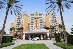 Grand building entrance with palm-lined landscaping, offering a resort-style welcome.
