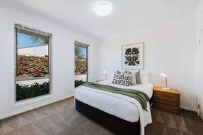 Just as stylish as the primary, the second queen room is flanked by side tables with lights for reading before bed.