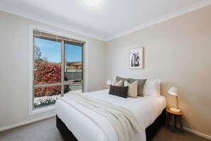A queen bed in the second bedroom is flanked by side table, allowing for some light reading before bed.