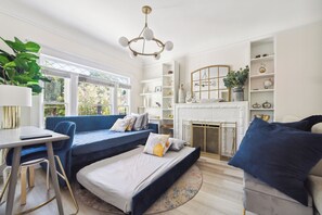 A living area featuring a comfortable blue sectional sofa that converts to bed.