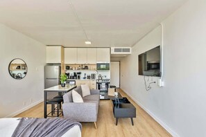 Living room with a 55" smart TV, coffee table that turns into a workspace, and plenty of room for your queen sized air mattress!