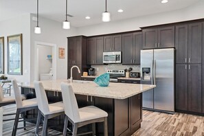 Gorgeous, fully-equipped kitchen featuring stainless steel appliances, and huge kitchen island that seats 4