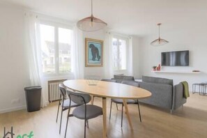 Salon avec TV HD et espace salle-à-manger, ouvert sur la cuisine. (4)