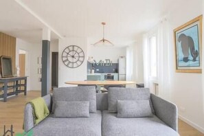 Salon avec TV HD et espace salle-à-manger, ouvert sur la cuisine. (1)