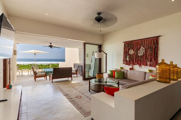 This beautifully designed living space features stylish decor, ample seating, and seamless access to the ocean breeze.