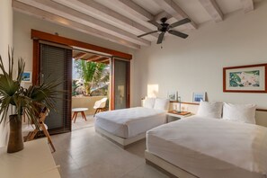 A bright and airy bedroom featuring twin beds, minimalist decor, and direct access to a private balcony.Tropical Outdoor-Inspired Bathroom
