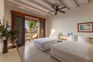 A bright and airy bedroom featuring twin beds, minimalist decor, and direct access to a private balcony.Tropical Outdoor-Inspired Bathroom