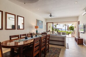 A spacious dining area with elegant wooden furniture, perfect for enjoying meals with a refreshing ocean breeze.