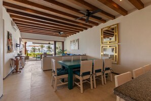 A spacious dining area with natural wood accents, stunning ocean views, and an inviting ambiance for gatherings.