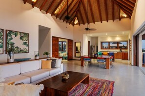 A spacious and beautifully designed living space featuring high ceilings, warm wood accents, and seamless indoor-outdoor flow.