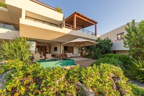 A breathtaking villa featuring a private plunge pool, lush tropical landscaping, and shaded outdoor lounge areas.