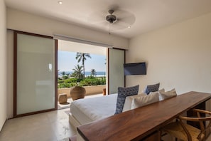 Wake up to the sight of waves crashing from this spacious bedroom featuring a private terrace and elegant furnishings.