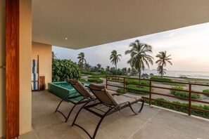 Relax and soak in the breathtaking ocean views from this spacious terrace with comfortable lounge chairs for the perfect getaway.