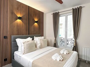 Bedroom full of light with ceiling fan and storage.