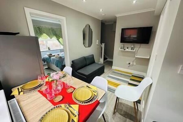 Living Room / Kitchen with space to sleep on the pull out sofa bed .