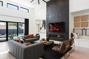 Open-concept living area featuring designer furnishings, a Smart TV, and fireplace