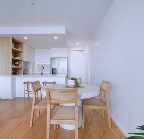 The open-plan dining area includes a four-seater table to share meals around, with additional seating available at the breakfast bar. 