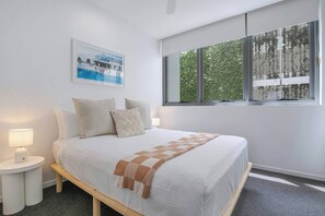 The spacious first bedroom includes a queen-size bed with side tables and reading lamps. A ceiling fan keeps you cool on hot summer nights.