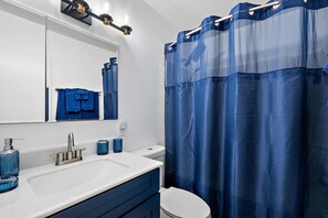Modern full bathroom with fresh towels and essential toiletries.