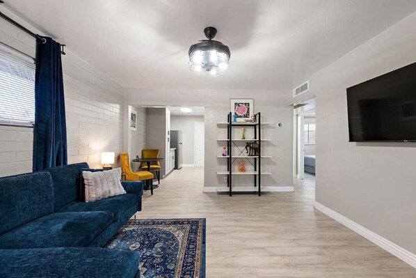 Bright living area with a cozy velvet sofa and modern decor.