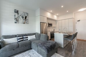 Living room is furnished with a pull-out couch and a Smart TV.