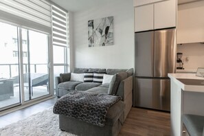 Living room is furnished with a pull-out couch and a Smart TV.
