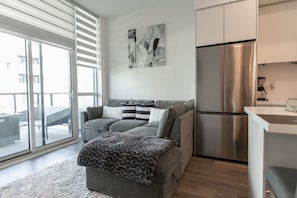 Living room is furnished with a pull-out couch and a Smart TV.