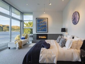 Master bedroom featuring lake views and a gas fireplace