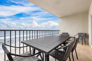A charming dining area on the private balcony, perfect for enjoying meals while taking in the breathtaking views of the Gulf of Mexico and the beach.