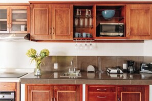 Kitchen with water dispensers, fridge, microwave, stove, dishes, pans, etc. 