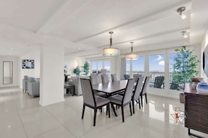 Elegant dining space perfect for family meals, surrounded by floor-to-ceiling windows providing scenic outdoor views.