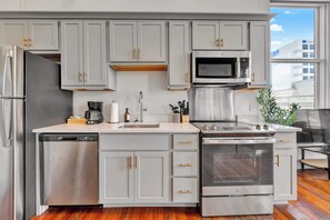 Modern kitchen with sleek stainless-steel appliances and ample counter space, plus a dining area good for four.