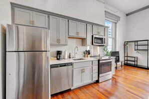 Modern kitchen with sleek stainless-steel appliances and ample counter space, plus a dining area good for four.