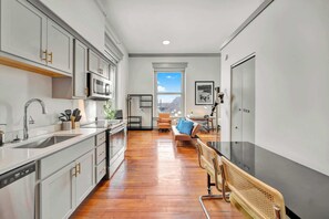 Modern kitchen with sleek stainless-steel appliances and ample counter space, plus a dining area good for four.