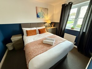Bedroom Retreat: Bright, stylish sanctuary with plush bedding and a serene garden view!
