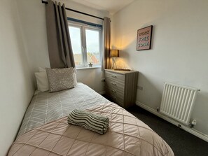 Serene Bedroom: Welcoming single bed with stylish decor and a calming workspace by the window!