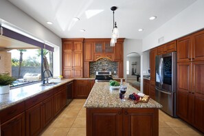 The fully equipped modern kitchen is stocked with all culinary essentials and stainless-steel appliances. (1st Floor)