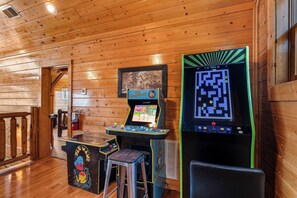 Game room with seating, TV, pool table, air hockey, & arcade