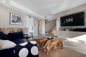 The living room features a sleeper sofa (2 guests) and a 75" Smart TV