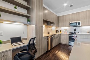 This contemporary kitchen is a chef's dream, featuring a large island, modern stainless steel appliances, and sleek cabinetry. The open layout ensures you can cook and entertain effortlessly, making it the perfect space for culinary creativity and social